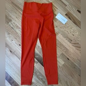 Athleta Transcend Stash Tight in Vibrant Orange